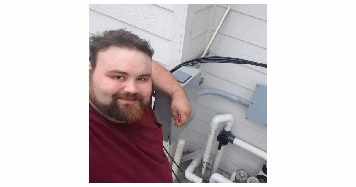 Chadwick Ferguson, Master Electrician and Co-Owner of Bright Haven Electric, smiling while working on an outdoor electrical panel installation.