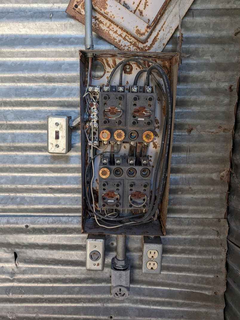 An old, outdated and unsafe electrical panel in a residential basement