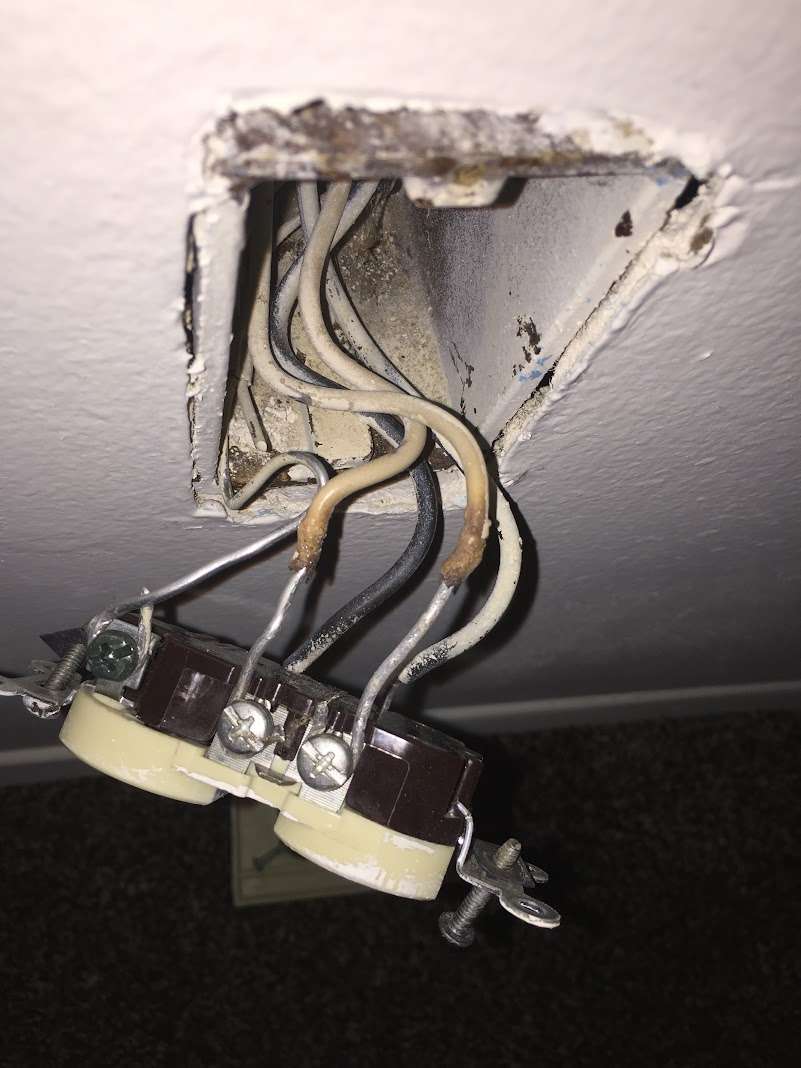 Electrician repairing a loose wiring connection inside a junction box that was causing flickering lights