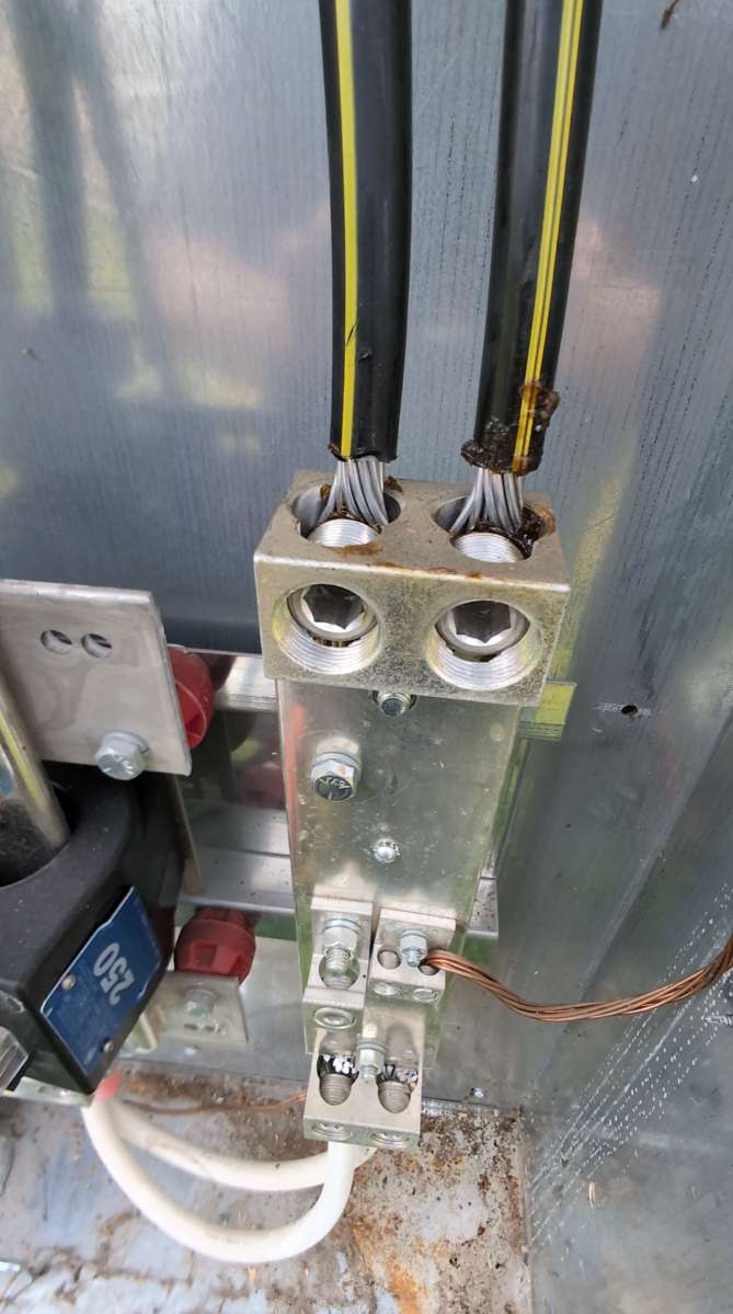 Oxide inhibitor aluminum connections — full CT cabinet view showing treated terminations with DeOx compound, current transformers, and grounding conductors by Bright Haven Electric.