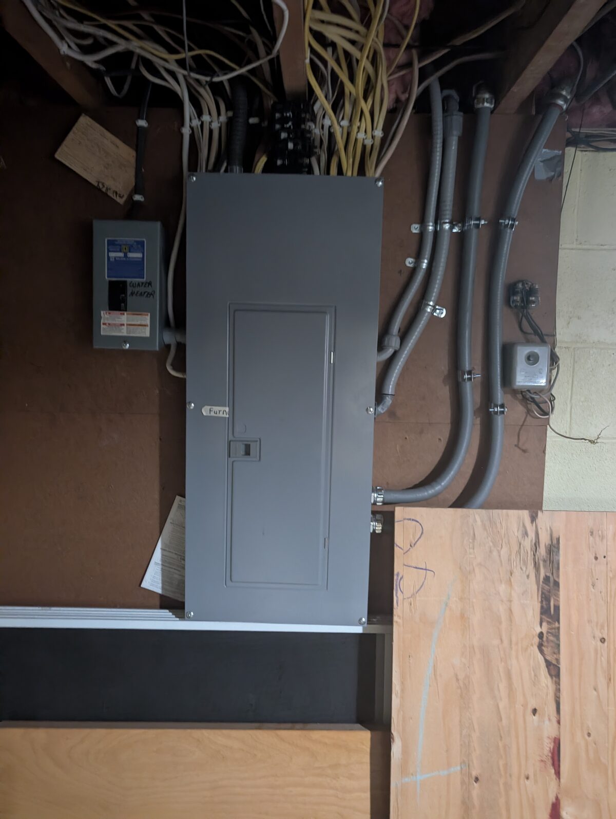 Finished electrical panel with three parallel liquidtight conduit runs for EV charger installation